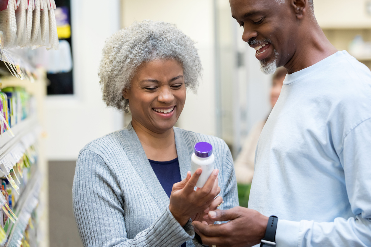 Seniors reading medicine bottle labels in pharmacy