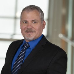 Christopher Galczynski Headshot in suit and blue shirt and tie