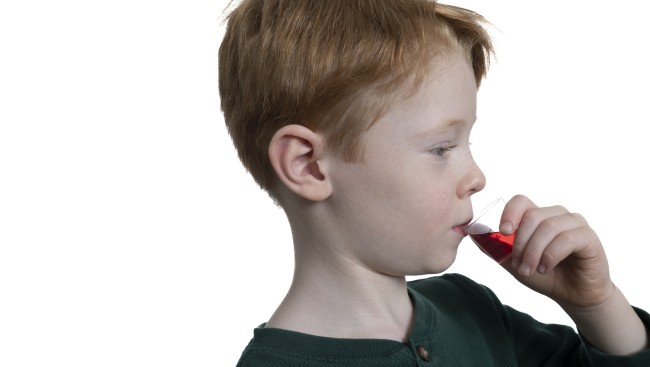 Caucasian/White boy with red hair drinking medicine profile view