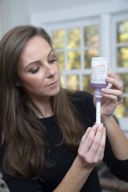 Caucasian/White woman measuring liquid medicine with syringe