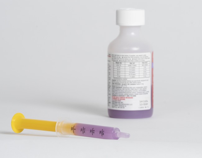 Liquid medicine bottle and syringe with purple medicine
