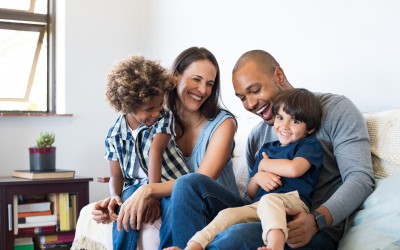 multi-racial couple with two children in living room multi-racial couple with two children in living room