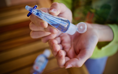 woman using travel sized hand sanitizer woman using travel sized hand sanitizer