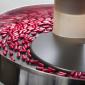 red capsules being sorted in a circular hopper