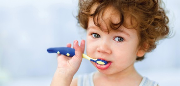 Young brown haired child brushing teeth