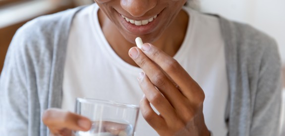 Young Woman Taking Dietary Supplement or Vitamin