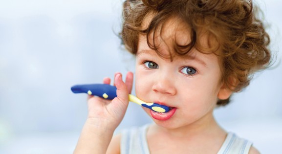 Young brown haired child brushing teeth