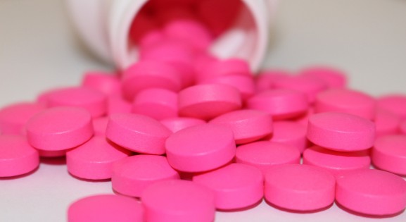 Pink Medicine Tablets pouring out of a bottle