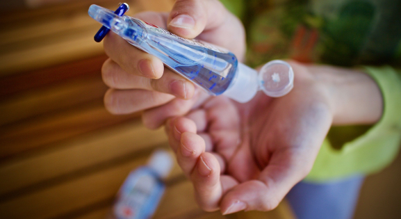 woman using travel sized hand sanitizer