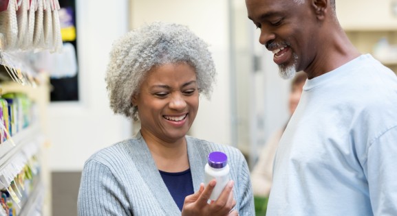 Seniors reading medicine bottle labels in pharmacy