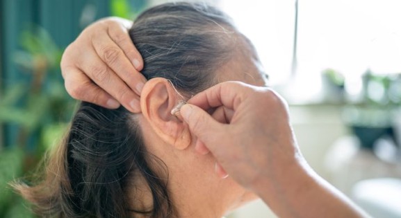 Woman attaching hearing aid