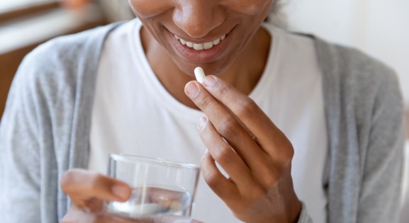 Young Woman Taking Dietary Supplement or Vitamin